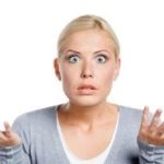 Confused woman with blonde hair, hands raised, depicting uncertainty in home maintenance for A-Plus Air Conditioning.