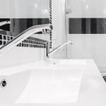 Sleek sink with chrome faucets and white porcelain surface, highlighting A-Plus home service solutions' modern aesthetic.