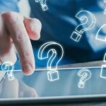 Person's finger pointing at a tablet with glowing question marks, representing HVAC service inquiries and home solutions.