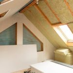 Renovation space with wooden beams and skylight, displaying insulation piles by A-Plus Air Conditioning.