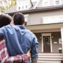 A couple embraces in front of a welcoming house, symbolizing home comfort and renovations by A-Plus HVAC Solutions.