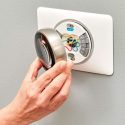 Hand gripping a safe dial, part of a home security system by A-Plus Air Conditioning & Home Solutions.