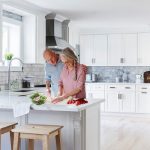 Elderly couple preparing vegetables in a modern kitchen, highlighting home remodeling by A-Plus Air Conditioning.